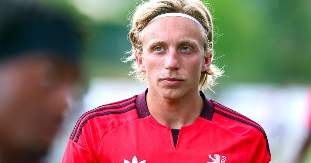 Pemain Olympique Lyonnais Mads Bidstrup sedang berjalan di pinggir lapangan latihan dengan balutan perban di kakinya.